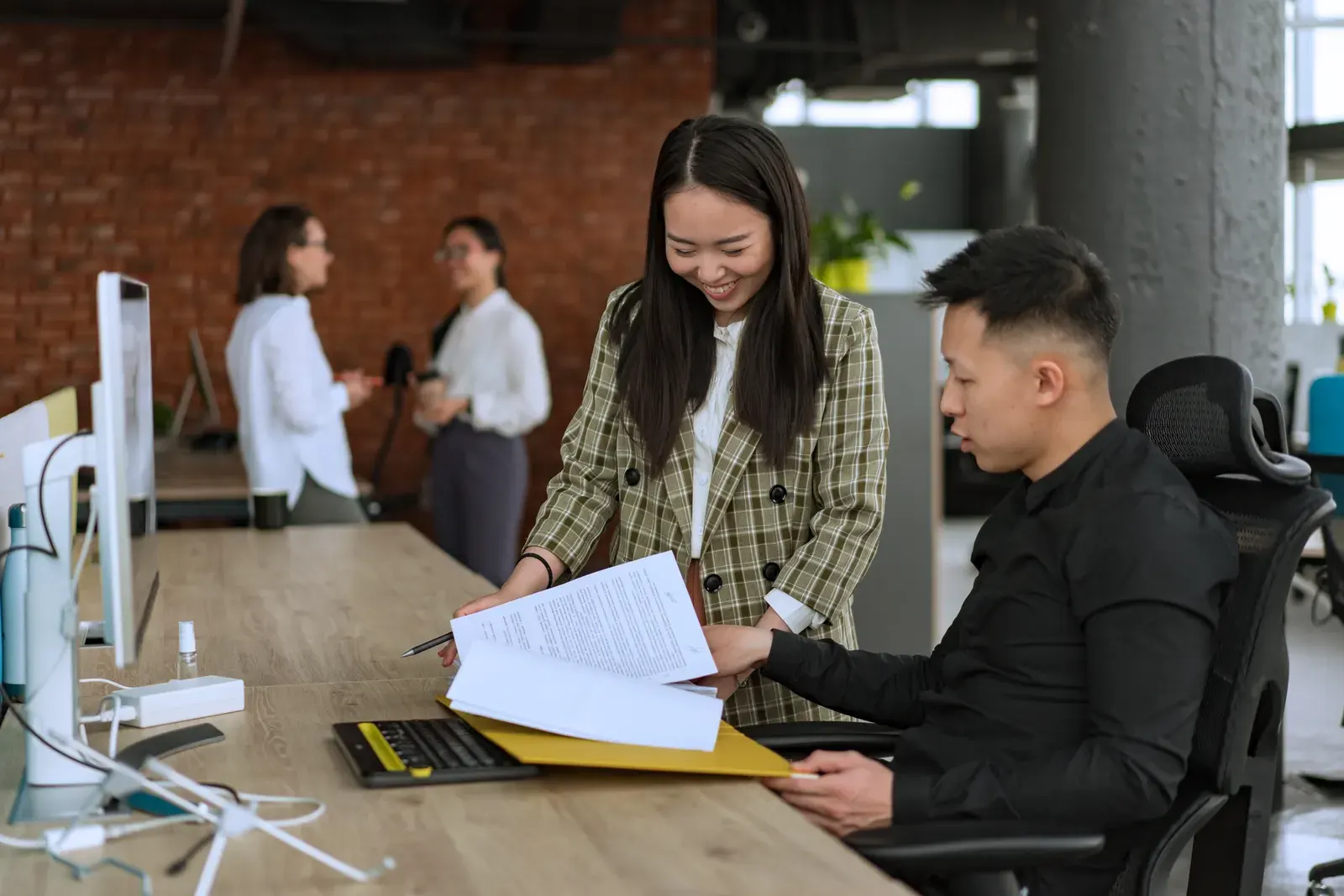 Professionals engaged in teamwork at a modern office desk reviewing documents.