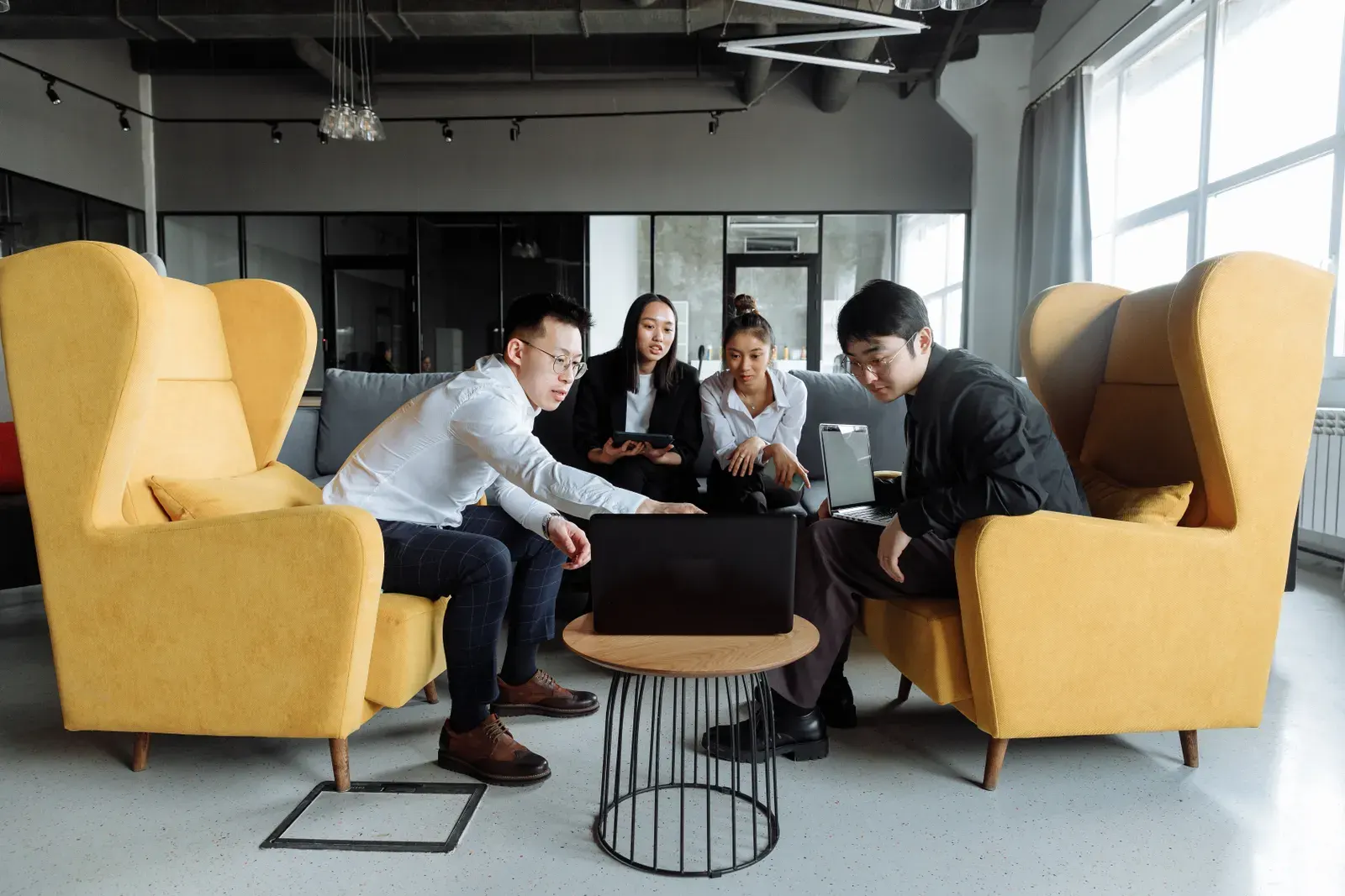A group of colleagues engaging in a collaborative meeting in a modern office setting.