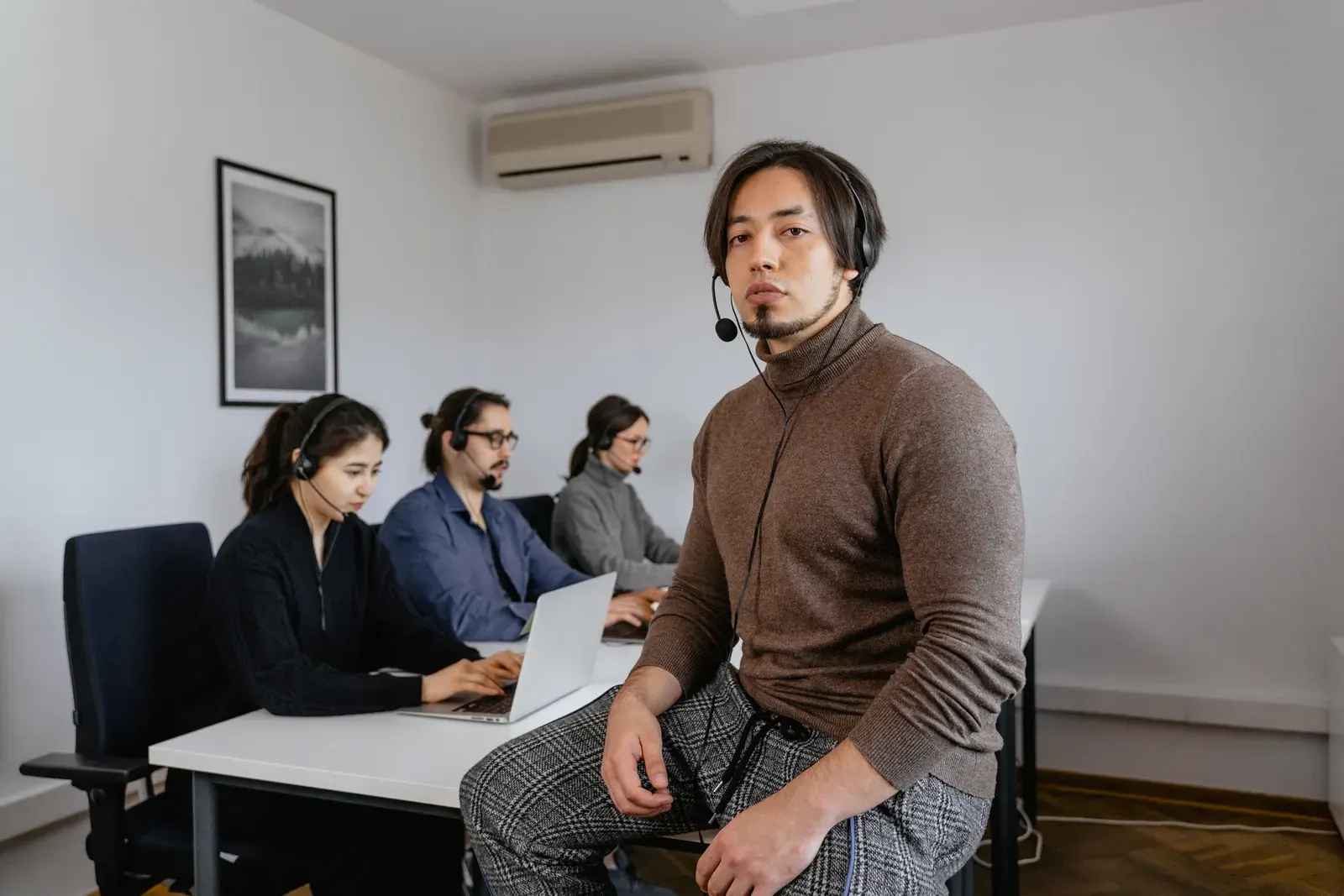 Focused call center team working together in a modern office space, collaborating on customer support tasks.