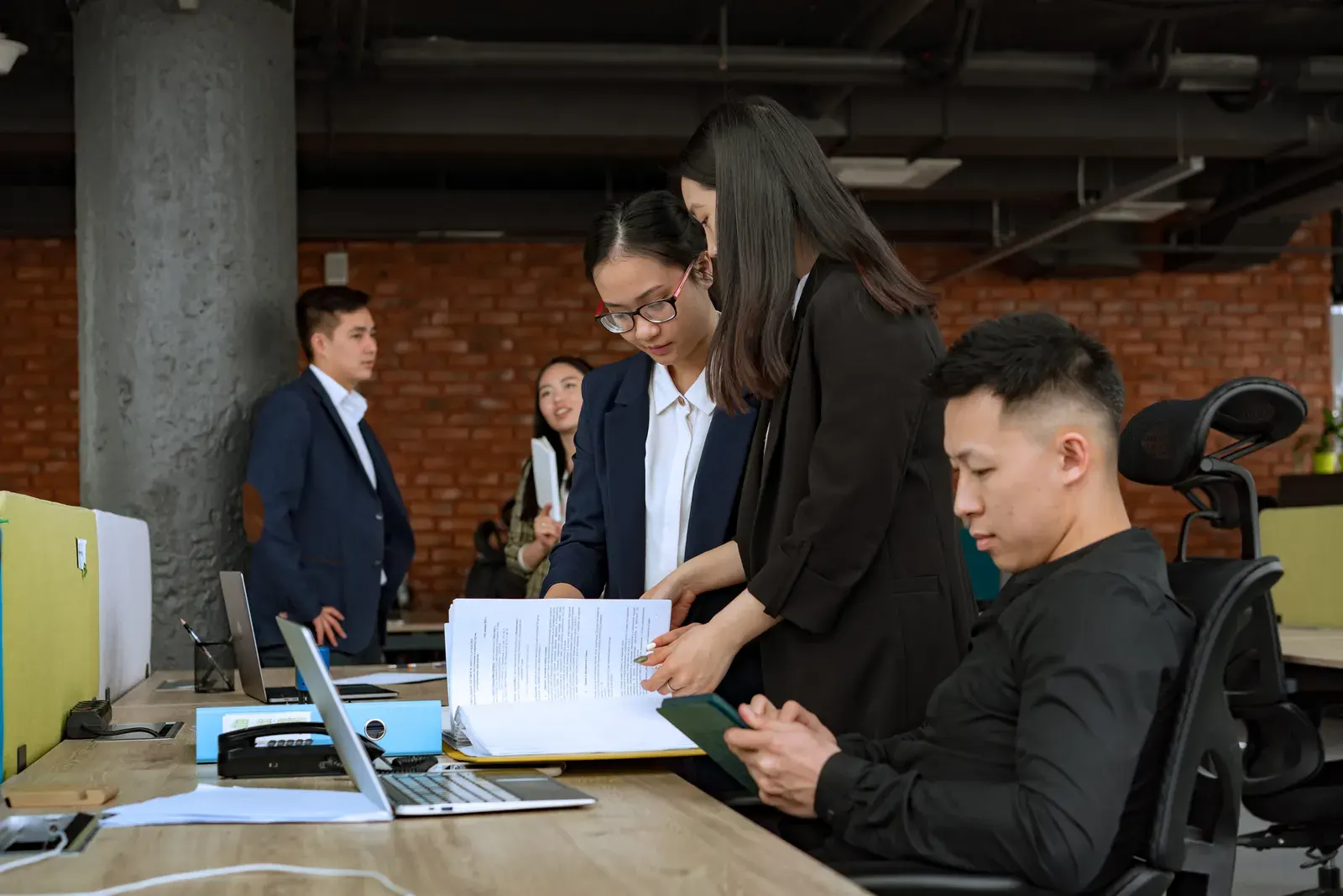 Professional team engaged in discussion and collaboration in a modern office environment.