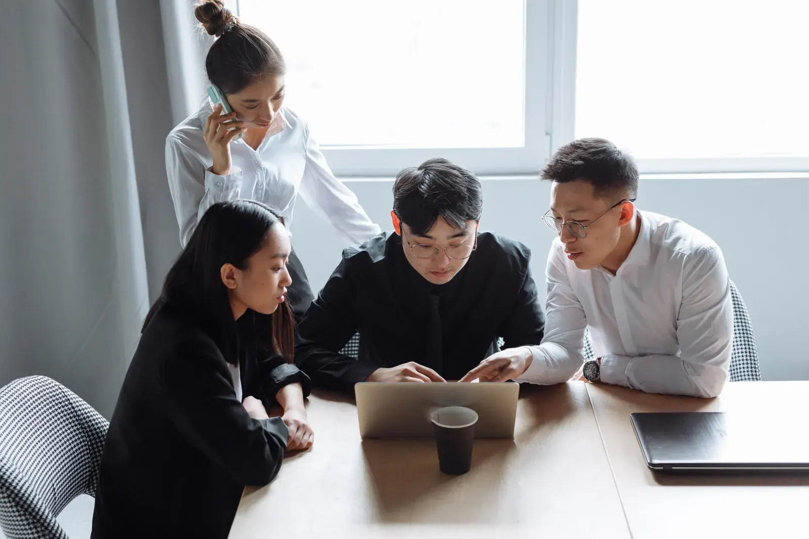 Business team brainstorming in an office setting with laptops and teamwork spirit.
