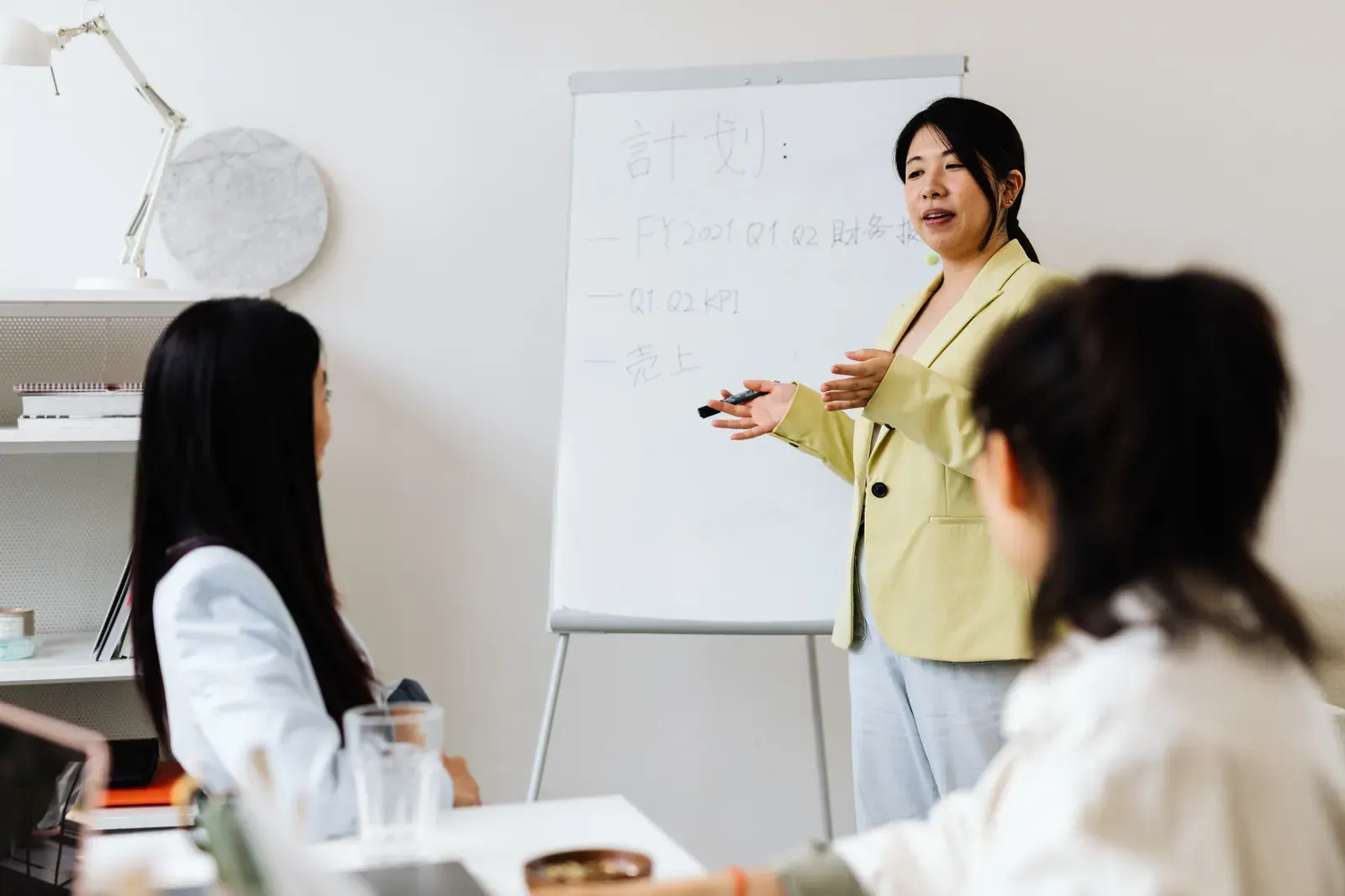 Confident businesswoman presenting strategy to colleagues in a modern office setting.