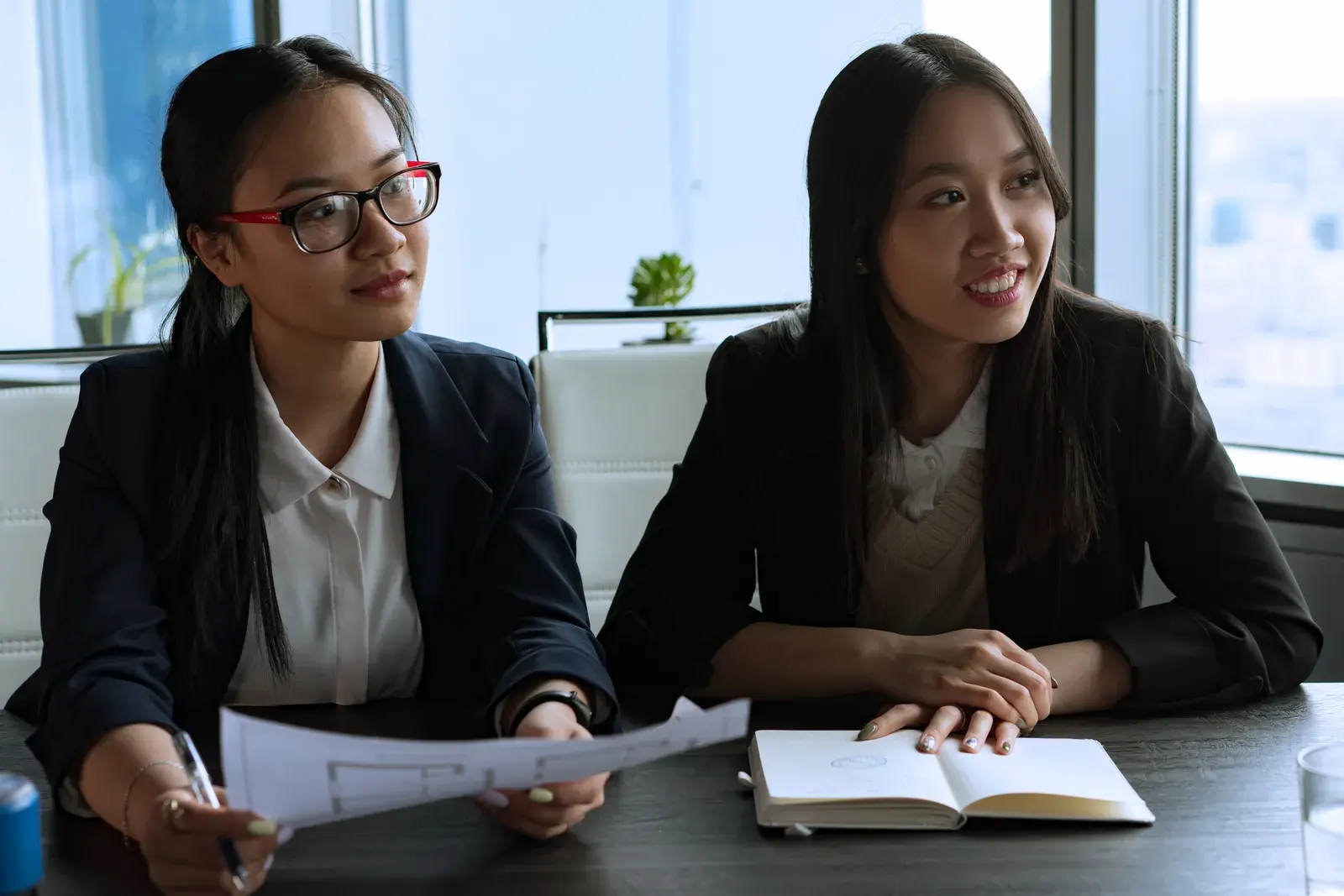 Two women engaged in a business meeting, discussing plans and ideas.
