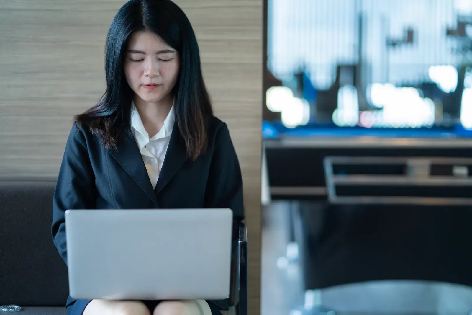Confident Asian businesswoman multitasking in a modern office setting in Bangkok.
