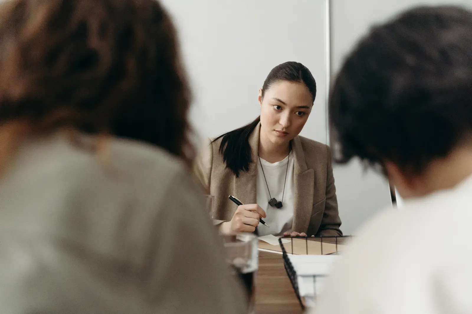 A serious woman works on project management during an office meeting.