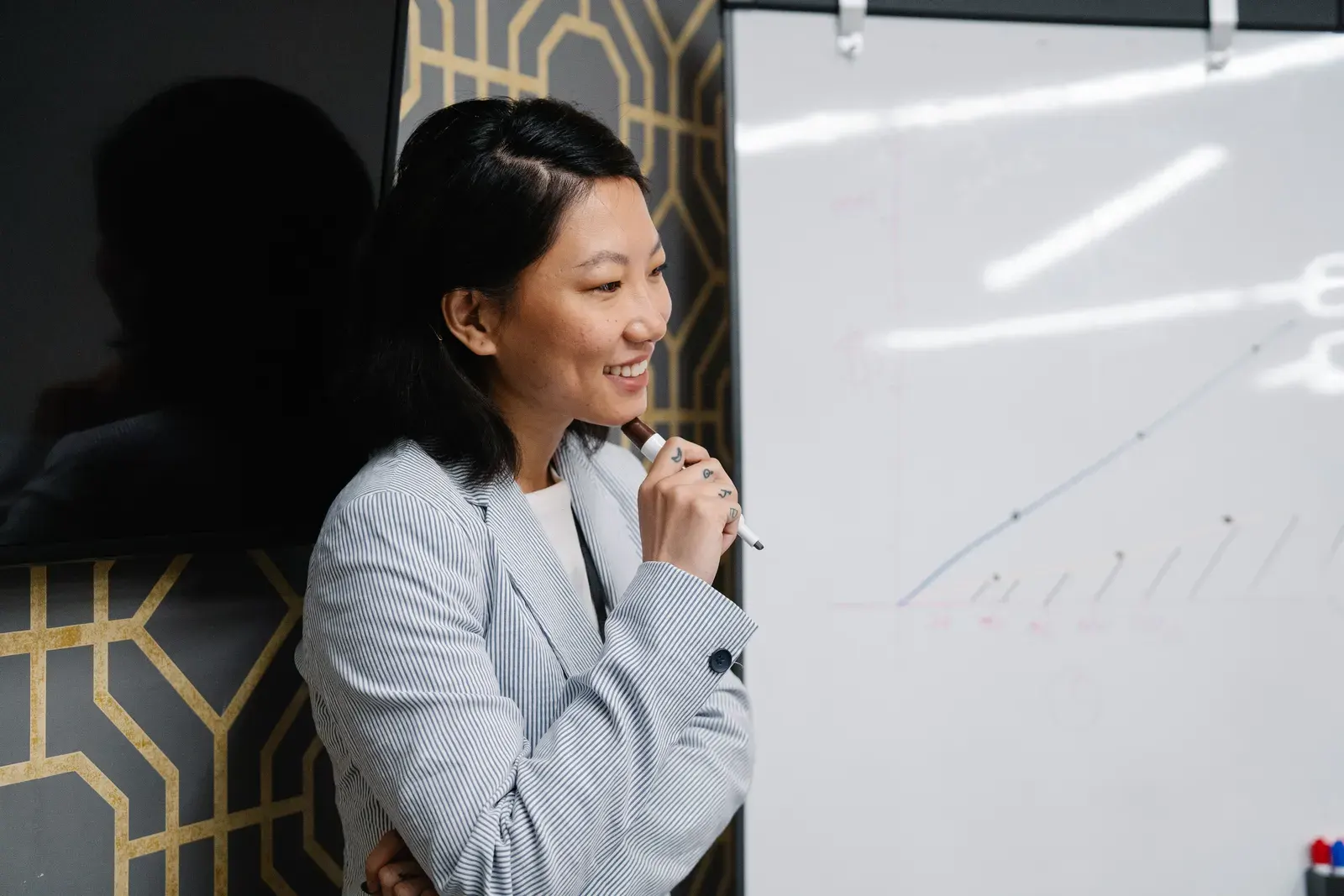 Confident Asian businesswoman presenting with a whiteboard in the office.
