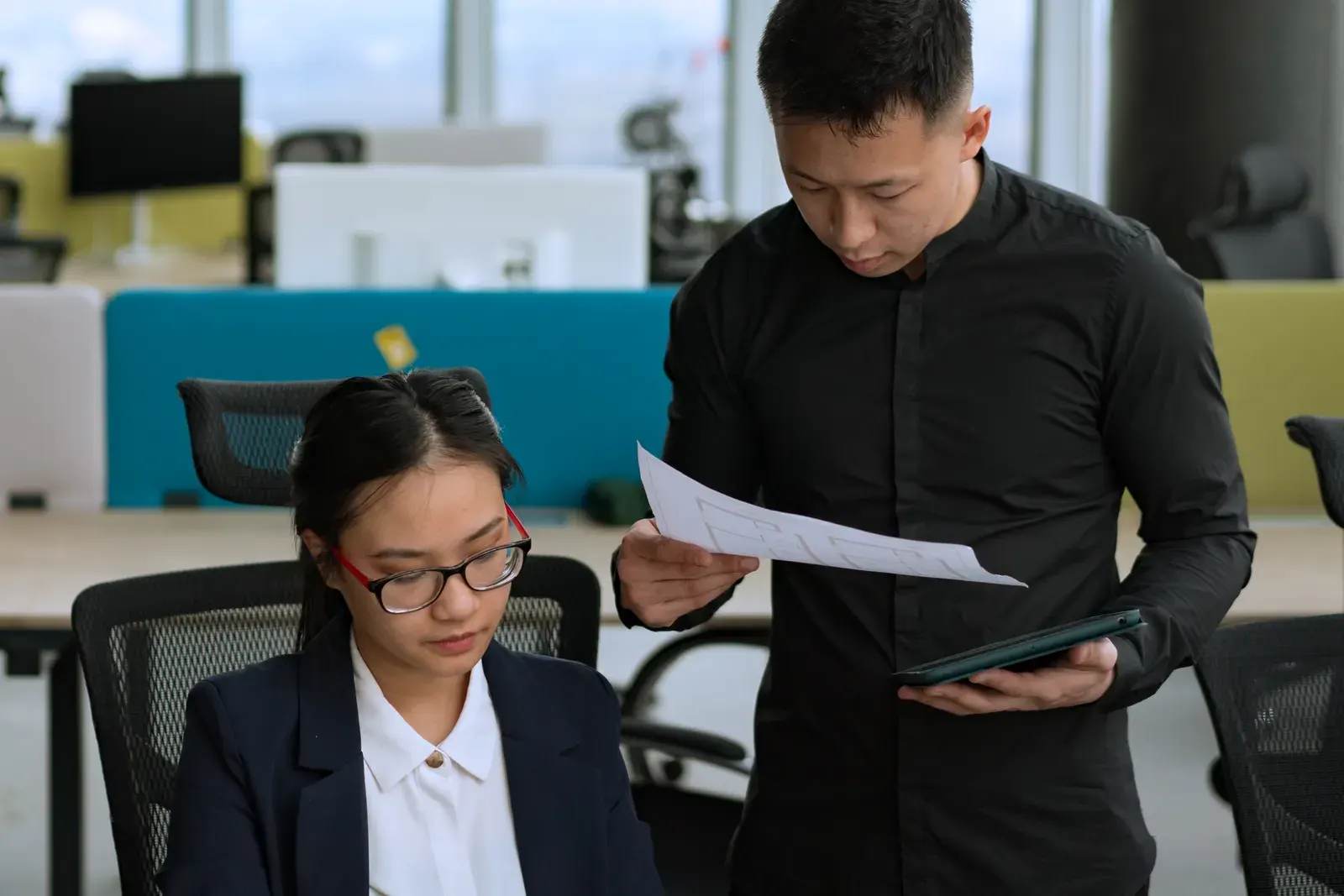 Two professionals collaborating on a project in a modern office environment.