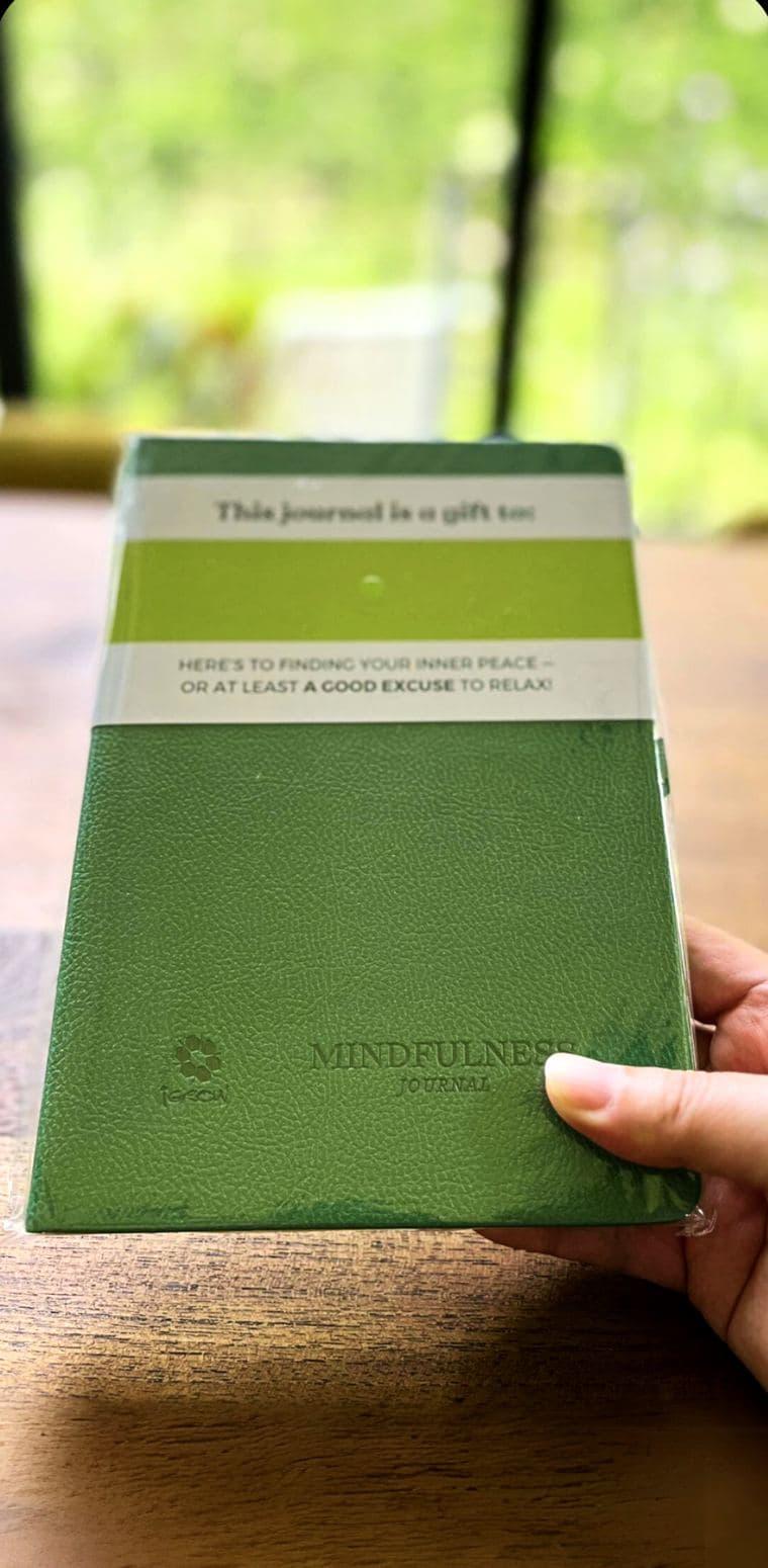 The iGROW Mindfulness Journal, embossed leather cover, held in hand