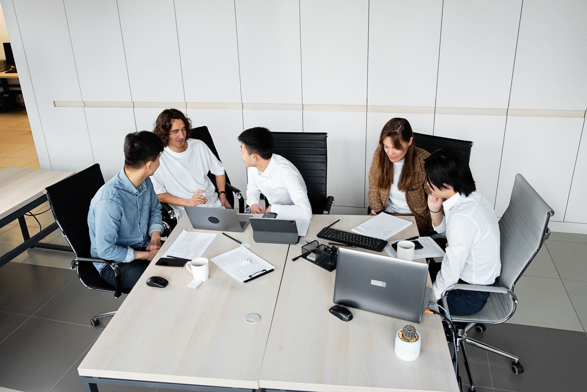 A diverse ASEAN team mid-workshop in a bright meeting room